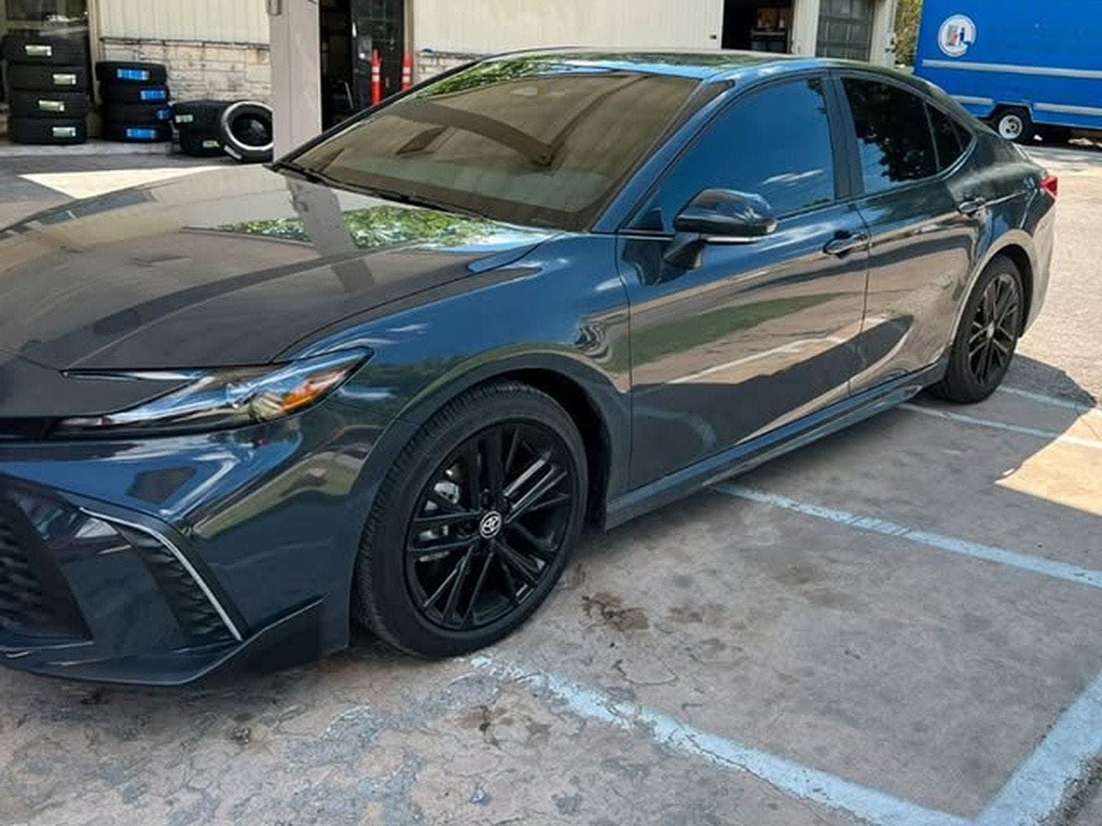 A Toyota Camry with full-car ceramic tint outside the shop